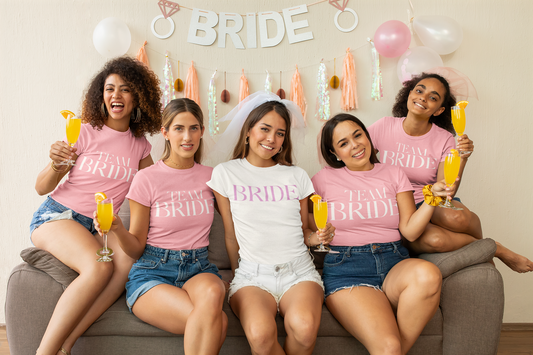 Grupo de amigas celebrando una despedida de soltera con playeras personalizadas temáticas, sonriendo.